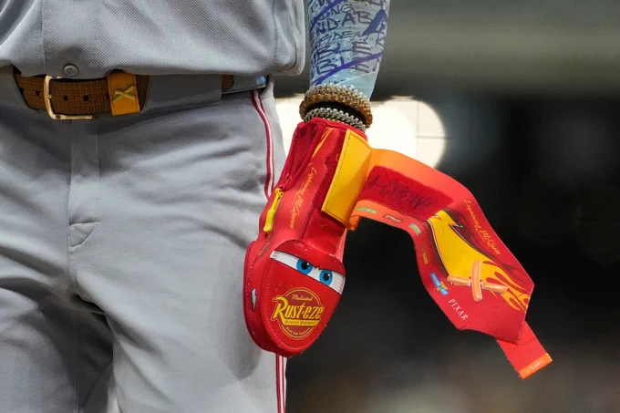 A close-up shot of the Lightning McQueen-themed sliding mitt worn by Elly De La Cruz.
